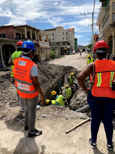 A group of people in protective gear repairing water pipes in Les Cayes. Photo Credit: DAI Global for USAID