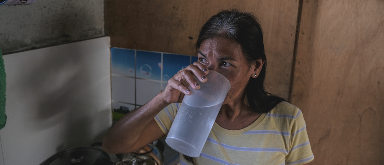 Woman sips a cup of clean water