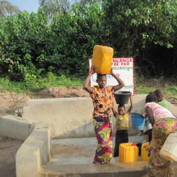Women gather water at a water point rehabilitated with USAID support as part of the Democratic Republic of Congo's Integrated Health Project. Photo credit: USAID/DRC