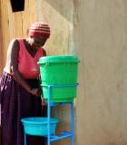 A mother washes her daughter’s hands outside her newly built latrine. Photo credit: Isuku Iwacu