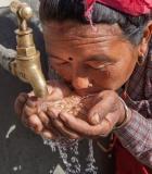 Nepali woman drinks water from tap